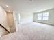 Bright bonus room with neutral carpet, white walls, and staircase access offering versatile living space at 1020 Channel Drop Lp, Zebulon, NC 27597