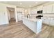 Stylish kitchen with central island, white cabinets, quartz countertops, and stainless appliances at 1020 Channel Drop Lp, Zebulon, NC 27597