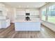 Well-lit kitchen boasts white cabinets, stainless appliances, quartz countertops, and spacious island at 1020 Channel Drop Lp, Zebulon, NC 27597