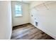 Well-lit laundry room features wood-look flooring and practical overhead shelving for organized storage at 1020 Channel Drop Lp, Zebulon, NC 27597
