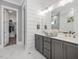 Bathroom showcasing double vanity, gray cabinets, shiplap accent wall, and marble tile flooring at 104 Pointe Park Cir, Holly Springs, NC 27540
