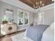 Light-filled bedroom boasts a wood-paneled ceiling, white trim, and an elegant chandelier at 104 Pointe Park Cir, Holly Springs, NC 27540
