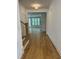 Hallway with hardwood floors, white walls, and an open view to a living space with lots of natural light at 104 Pointe Park Cir, Holly Springs, NC 27540