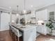 Bright kitchen featuring a large island with seating, pendant lighting and modern appliances at 104 Pointe Park Cir, Holly Springs, NC 27540