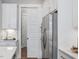 Kitchen detail showcasing white cabinetry, stainless steel refrigerator, and pantry at 104 Pointe Park Cir, Holly Springs, NC 27540