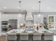 Bright kitchen featuring a large island with seating, pendant lighting and modern appliances at 104 Pointe Park Cir, Holly Springs, NC 27540