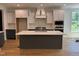 Modern kitchen features stainless steel appliances, a central island, and sleek white and gray cabinetry at 104 Pointe Park Cir, Holly Springs, NC 27540