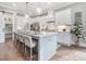 Bright kitchen featuring a large island with seating, pendant lighting and modern appliances at 104 Pointe Park Cir, Holly Springs, NC 27540
