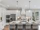 Bright kitchen featuring a large island with seating, pendant lighting and modern appliances at 104 Pointe Park Cir, Holly Springs, NC 27540