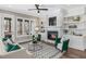 Inviting living room with a fireplace, built-in shelving, comfortable seating, and lots of natural light at 104 Pointe Park Cir, Holly Springs, NC 27540