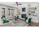 Bright living room featuring fireplace, built-in shelving, and access to an outdoor porch at 104 Pointe Park Cir, Holly Springs, NC 27540