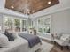 Serene main bedroom with wood tray ceiling, large windows, and stylish furnishings at 104 Pointe Park Cir, Holly Springs, NC 27540