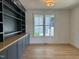 Office with a built-in bookshelf and cabinet, light wood floors, and a window providing natural light at 104 Pointe Park Cir, Holly Springs, NC 27540