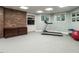 Finished basement with a treadmill, exposed brick accent wall and shelving for storage and entertainment at 107 Marseille Pl, Cary, NC 27511