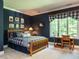 Inviting bedroom features dark blue walls, a wooden bed frame, and natural light from a large window at 107 Marseille Pl, Cary, NC 27511