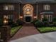Home exterior at dusk, highlighting the walkway and illuminated arched entry way at 107 Marseille Pl, Cary, NC 27511