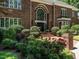 Close up of brick front entrance of home, showcasing arched window and mature landscaping at 107 Marseille Pl, Cary, NC 27511