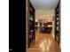 Hallway with hardwood floors, built-in bookcases, and a glimpse of the kitchen at 107 Marseille Pl, Cary, NC 27511