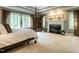 Spacious main bedroom featuring a fireplace, decorative trim, a four-poster bed, and large windows at 107 Marseille Pl, Cary, NC 27511