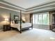 Bright main bedroom featuring a four poster bed, neutral colors, decorative trim, and large windows at 107 Marseille Pl, Cary, NC 27511