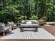 Inviting outdoor patio features a stylish seating area and a serene view of the surrounding trees at 107 Marseille Pl, Cary, NC 27511