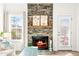 Living room with a stone fireplace, mantel decorations, and bright natural light at 1126 Talisker Way, Burlington, NC 27215