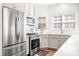 Modern kitchen featuring stainless steel appliances, a subway tile backsplash, and stylish gray cabinets at 1126 Talisker Way, Burlington, NC 27215