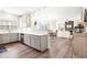 Open-concept kitchen featuring white cabinetry, a breakfast bar, and hardwood floors at 1126 Talisker Way, Burlington, NC 27215