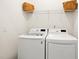 Well-lit laundry area featuring a modern washer and dryer with overhead shelf storage at 1126 Talisker Way, Burlington, NC 27215