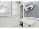 Cozy bathroom features a pedestal sink, tiled floor, and shuttered windows, all in a classic design at 1200 Glenwood Ave, Raleigh, NC 27605
