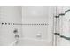 Bright bathroom with white tiled walls and a classic bathtub with shower at 1200 Glenwood Ave, Raleigh, NC 27605