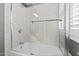 Clean and bright bathtub with a shower featuring white tiles and a glass door at 1200 Glenwood Ave, Raleigh, NC 27605