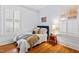 Cozy bedroom with hardwood floors, American flag art, and plenty of natural light at 1200 Glenwood Ave, Raleigh, NC 27605
