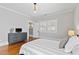 Bedroom features hardwood floors, neutral walls, shutters, and a gray dresser at 1200 Glenwood Ave, Raleigh, NC 27605