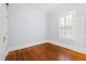Bright bedroom with hardwood floors, fresh paint, and natural light from a shuttered window at 1200 Glenwood Ave, Raleigh, NC 27605