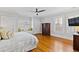 Bright bedroom features hardwood floors, white walls, shutters, and a ceiling fan at 1200 Glenwood Ave, Raleigh, NC 27605