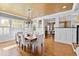 Elegant dining room featuring a chandelier, hardwood floors, large windows, and a table with seating at 1200 Glenwood Ave, Raleigh, NC 27605