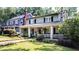 Inviting two-story home with a large front porch surrounded by manicured landscaping at 1200 Glenwood Ave, Raleigh, NC 27605