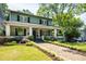 Charming two-story home with a brick walkway, covered front porch and manicured landscaping at 1200 Glenwood Ave, Raleigh, NC 27605