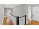 Second-floor hallway with hardwood flooring, painted walls, and access to bedrooms at 1200 Glenwood Ave, Raleigh, NC 27605