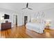 Spacious main bedroom with hardwood floors, ceiling fan, decorative mirrors, and a walk in closet at 1200 Glenwood Ave, Raleigh, NC 27605