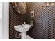 Unique powder room with a pedestal sink and decorative wallpaper at 1200 Glenwood Ave, Raleigh, NC 27605