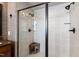 Modern bathroom featuring a glass-enclosed shower with stone-look tile and a seat at 1200 Glenwood Ave, Raleigh, NC 27605