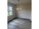 Dining area featuring luxury vinyl plank flooring, a modern chandelier and natural light from a large window at 122 Reece Dr, Sanford, NC 27332