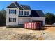 Charming two-story home with attached garage, black roof, and an empty lot at 122 Reece Dr, Sanford, NC 27332