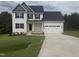 Charming two-story home with a two-car garage, a well-manicured lawn, and dark shutters against the light siding at 122 Reece Dr, Sanford, NC 27332