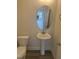 Cozy half bathroom featuring a pedestal sink, round mirror and a toilet with vinyl plank flooring at 122 Reece Dr, Sanford, NC 27332