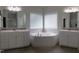 Bathroom features double sinks, white cabinets, a soaking tub and tile flooring at 1520 Village Grove Ct, Hillsborough, NC 27278