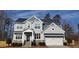 Beautiful two-story home showcasing a classic design, a well-manicured lawn, and an attached two-car garage at 1520 Village Grove Ct, Hillsborough, NC 27278