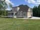 View of the home's backyard, showcasing the screened porch, driveway, and spacious lawn at 165 Cotton Fields Ln # 25, Fuquay Varina, NC 27526